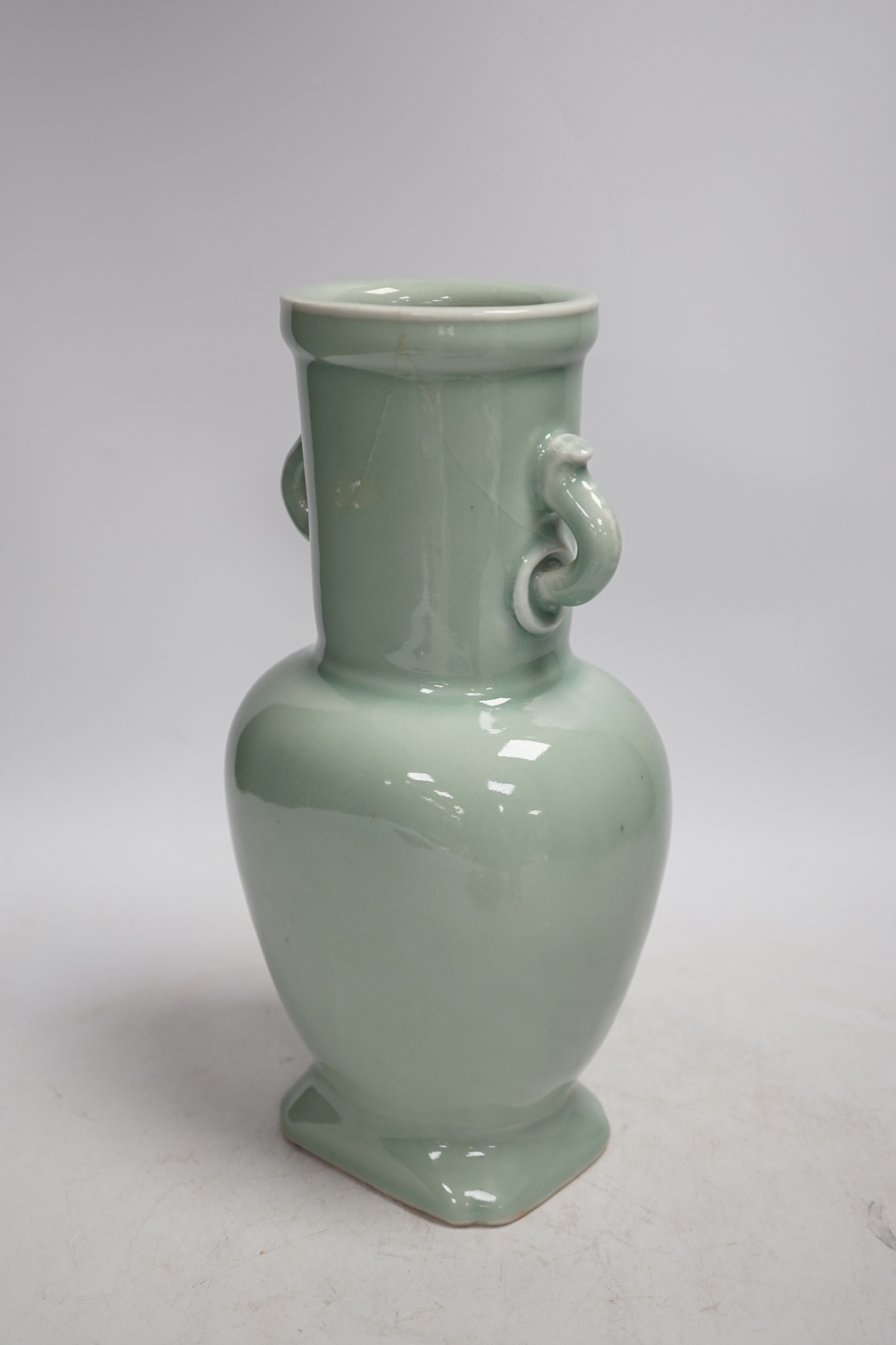 A Chinese celadon glazed two handled vase and a Chinese blue and white vase and dish, celadon vase 28.5cm high. Condition - celadon vase has a firing flaw and large crack, both blue and white vase are in damaged conditio